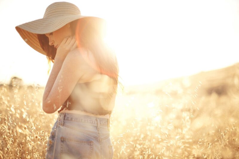 woman in field at sunset