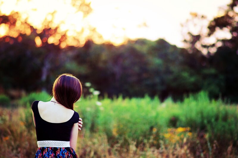 woman in field at sunset