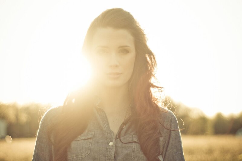 woman in field at sunset