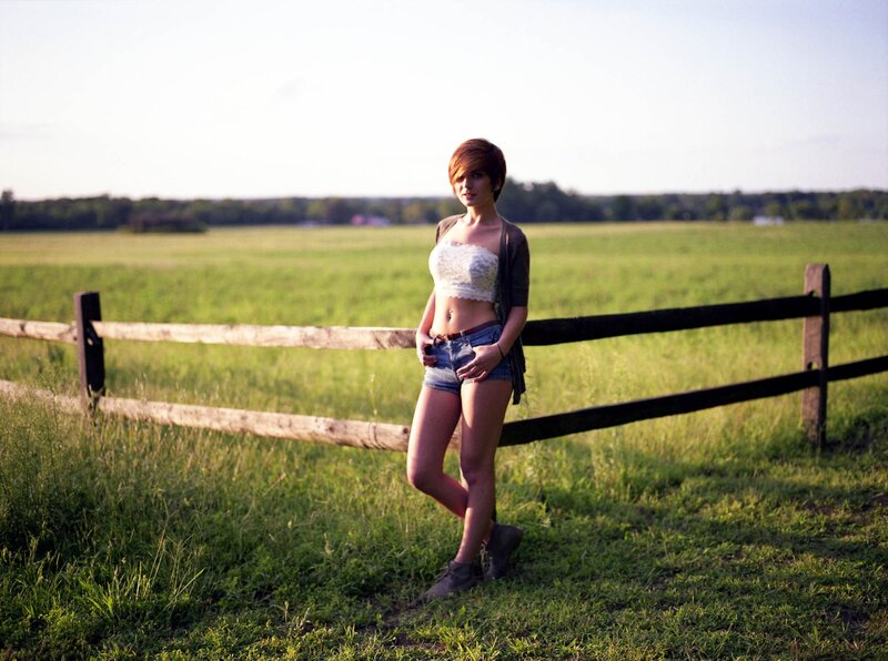 woman in field by fence