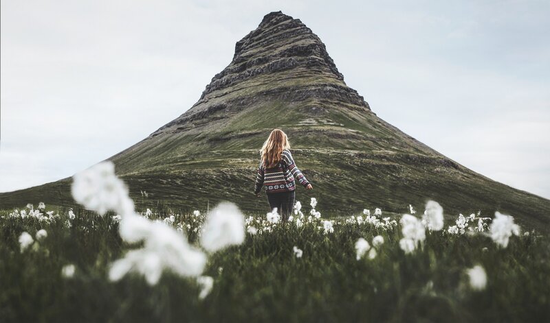 Woman in Field Facing Mountain