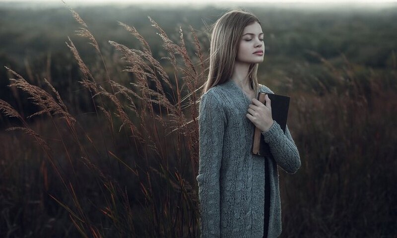 Woman in Field Holding Book