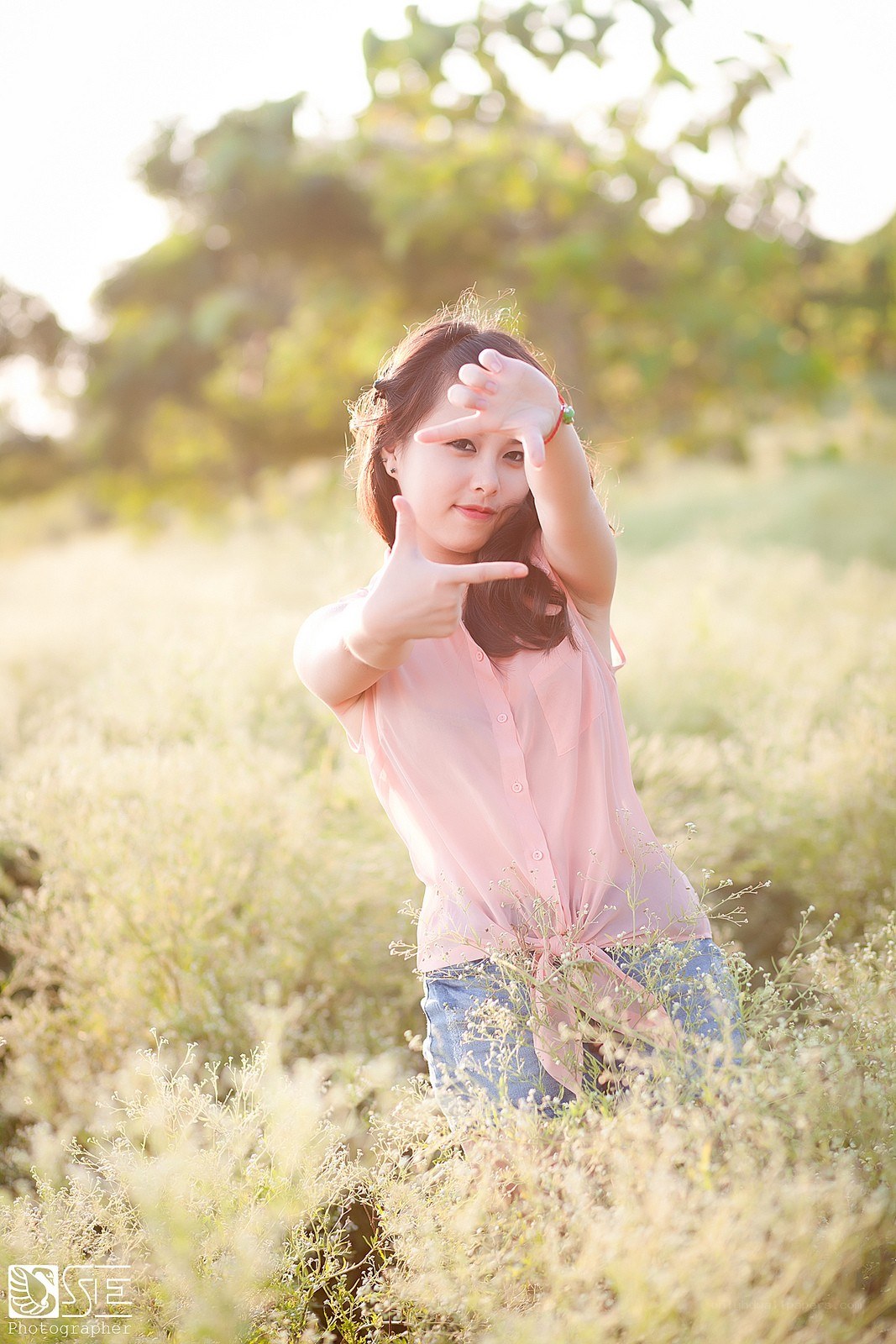 Woman in field making frame gesture