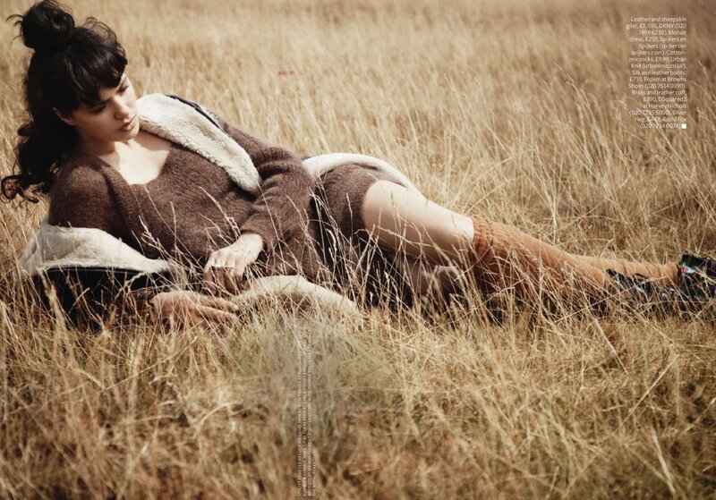 woman in field wearing sweater