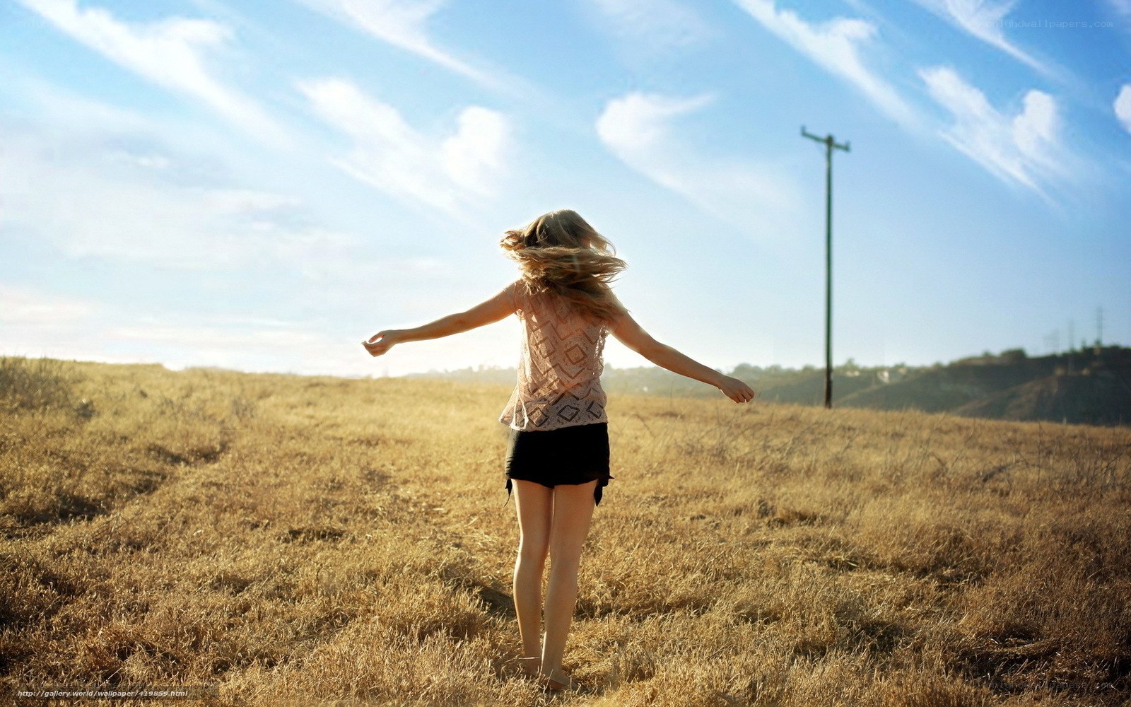 woman in field with arms outstretched