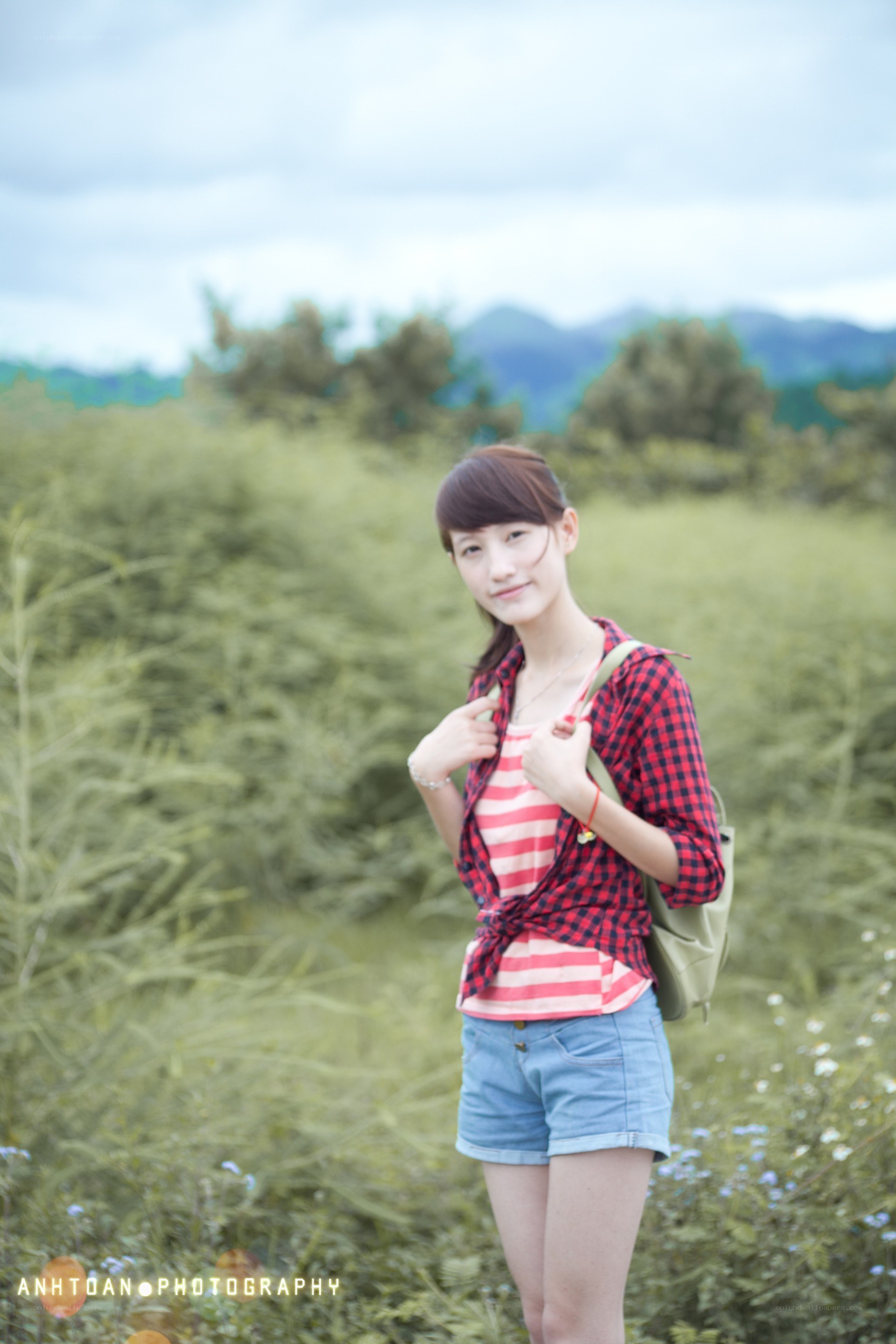 Woman in field with backpack