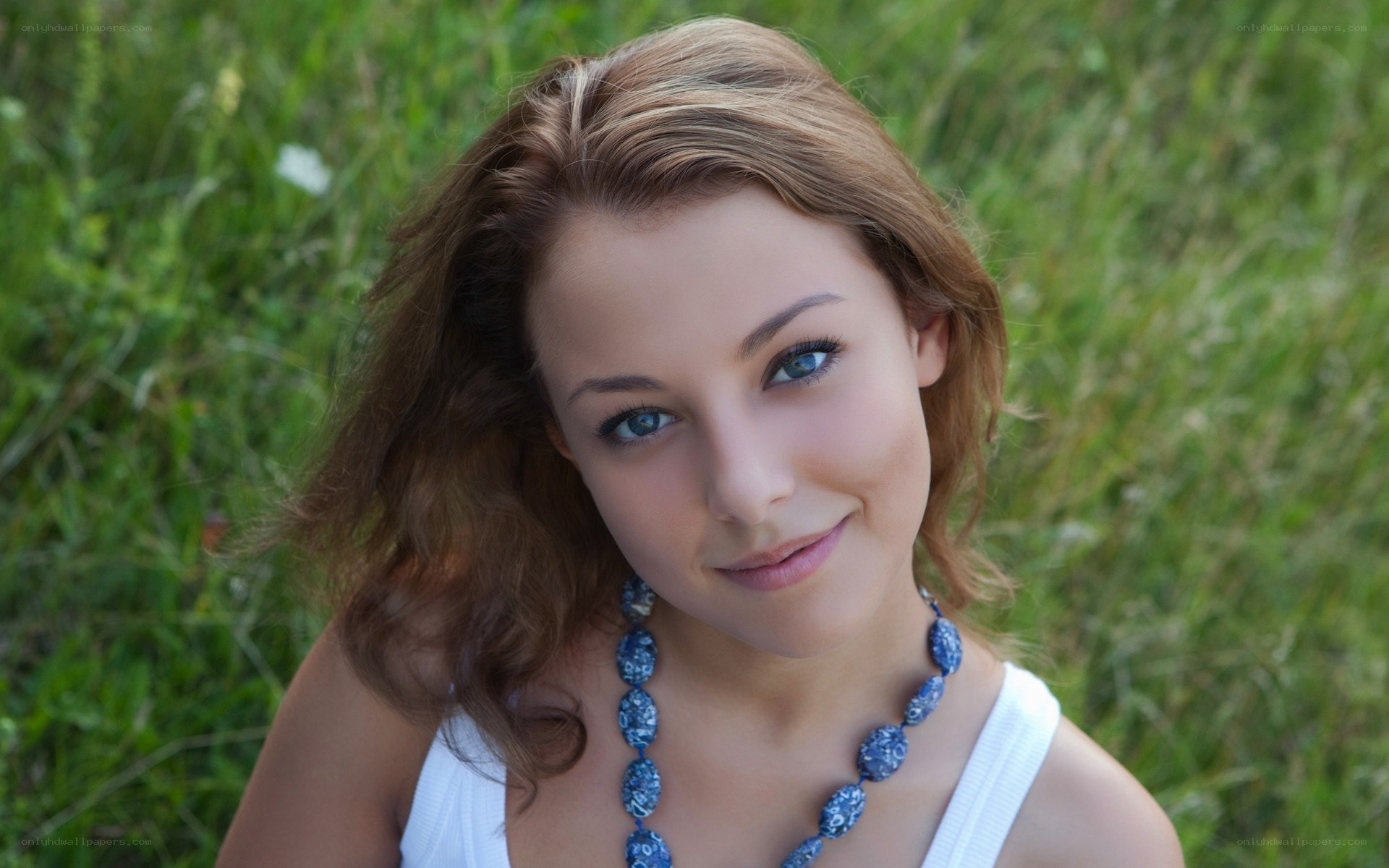 woman in field with blue necklace