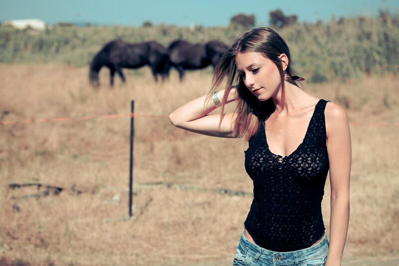 woman in field with horses