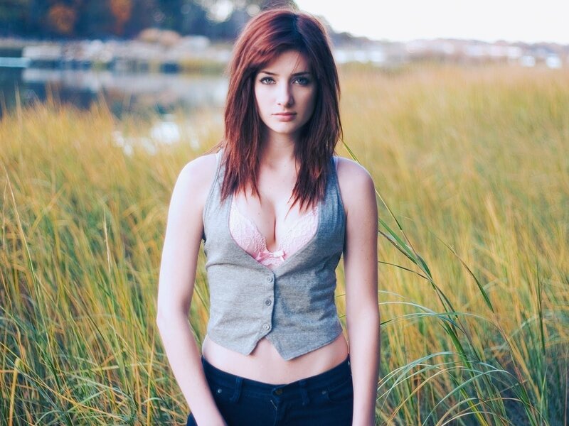 woman in field with lake
