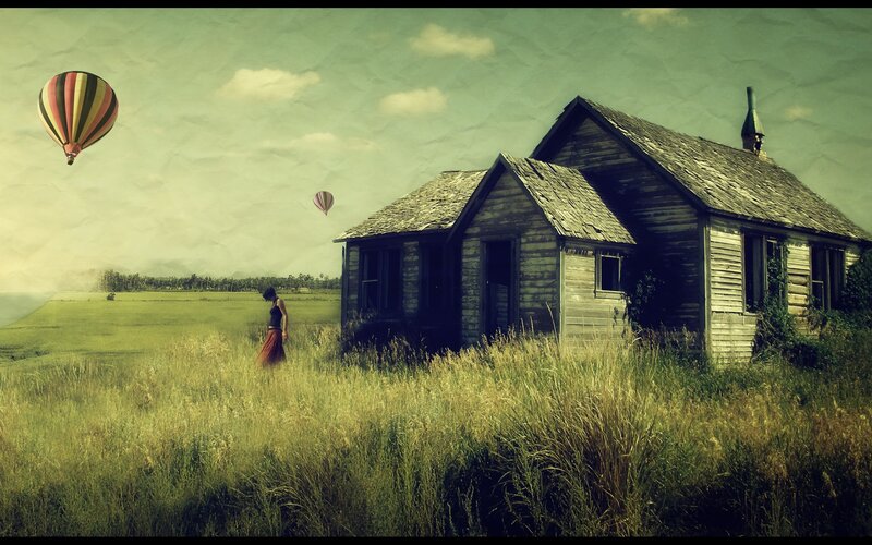 Woman in field with old house