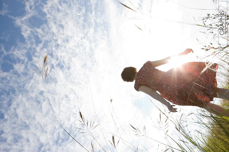 Woman in field with sun behind