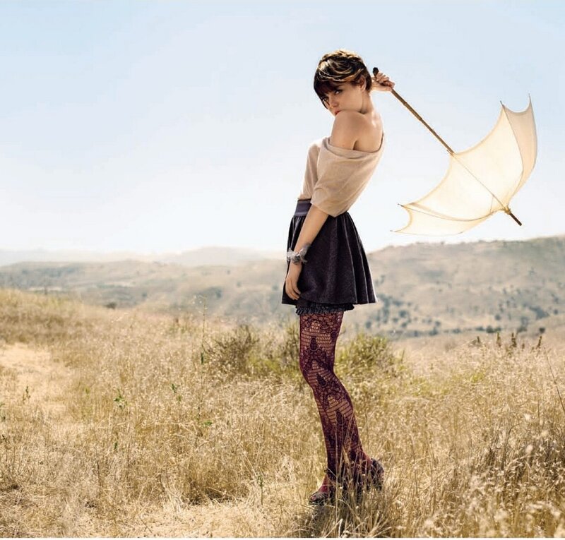 Woman in field with umbrella