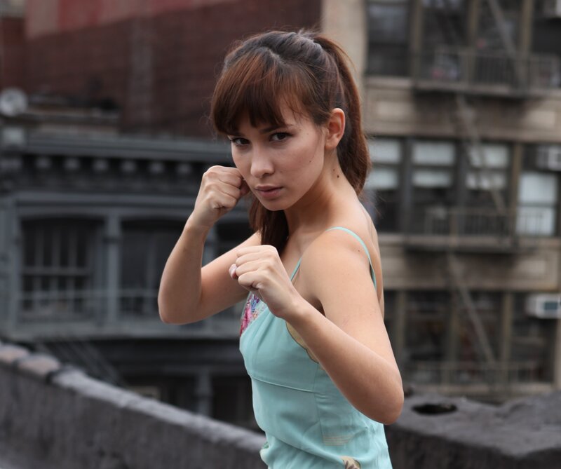 woman in fighting stance on rooftop
