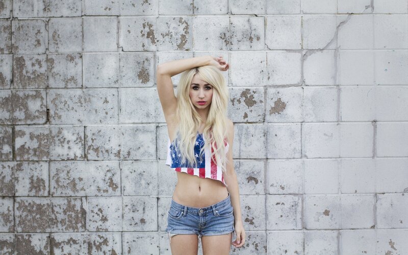 woman in flag top against brick wall