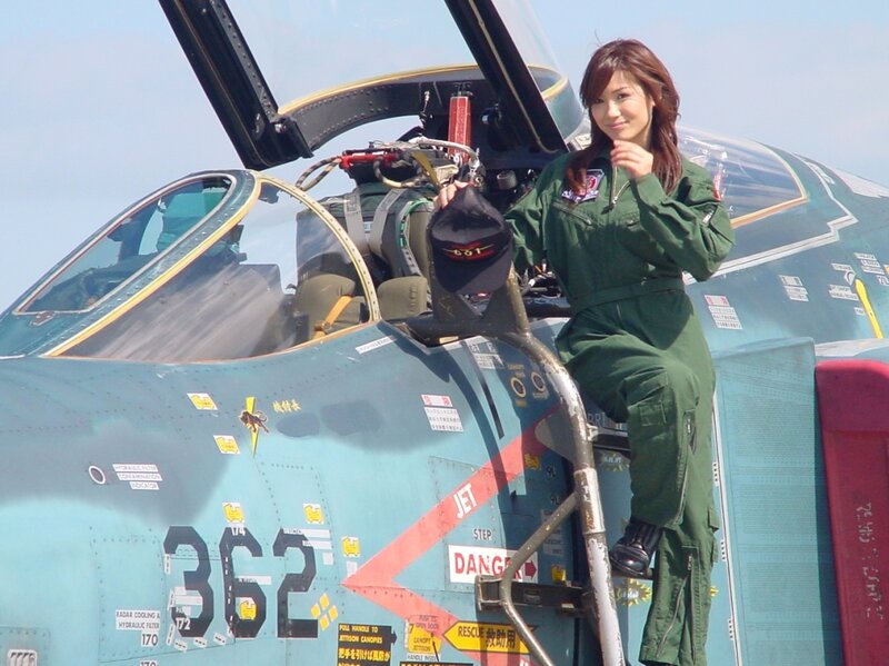 Woman in flight suit by jet