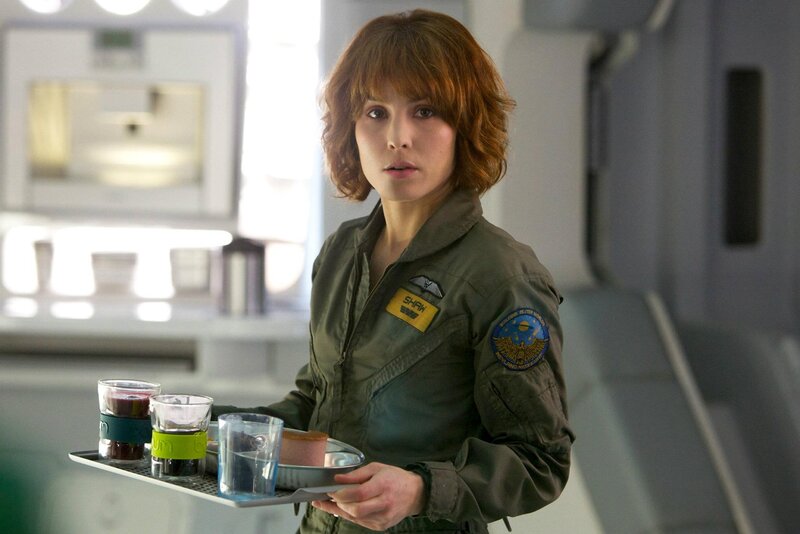 Woman in flight suit holding tray