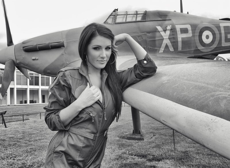 Woman in flight suit near vintage plane