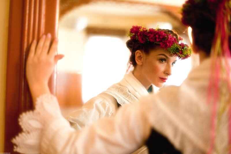 woman in floral crown looking at mirror