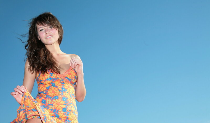 woman in floral dress against blue sky