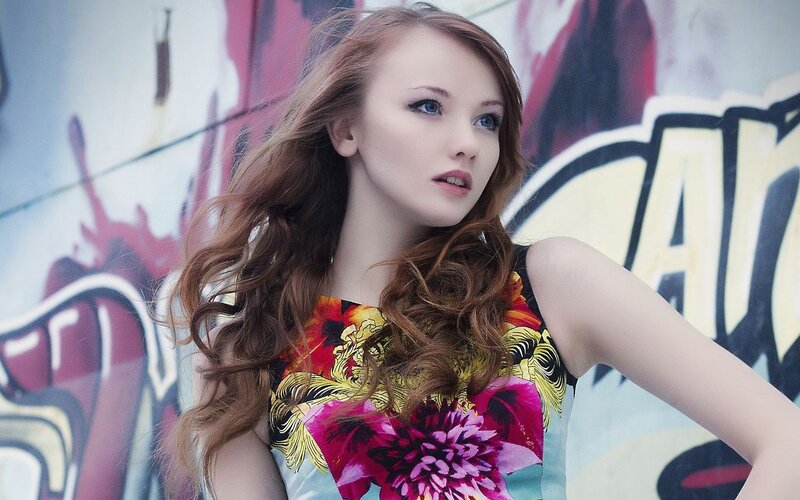 woman in floral dress against graffiti