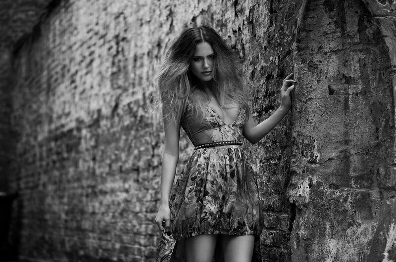 woman in floral dress against wall