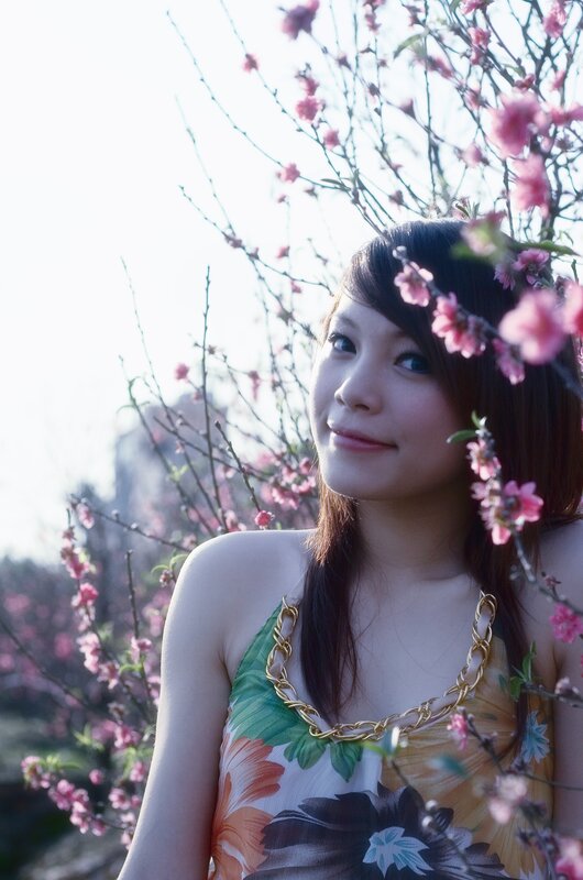 woman in floral dress among blossoms