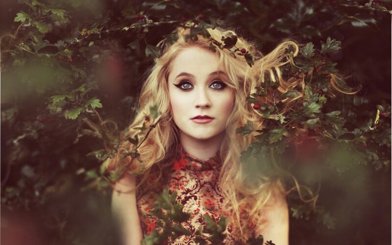 woman in floral dress among foliage
