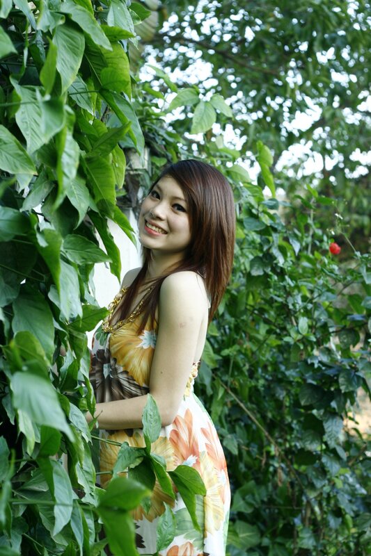 woman in floral dress among greenery