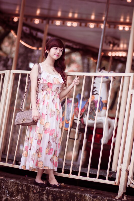 Woman in floral dress at carousel