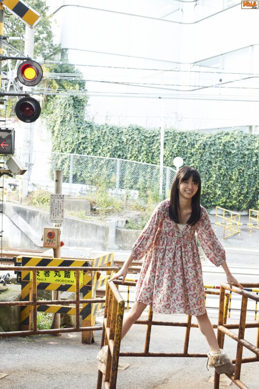 Woman in floral dress at railway crossing