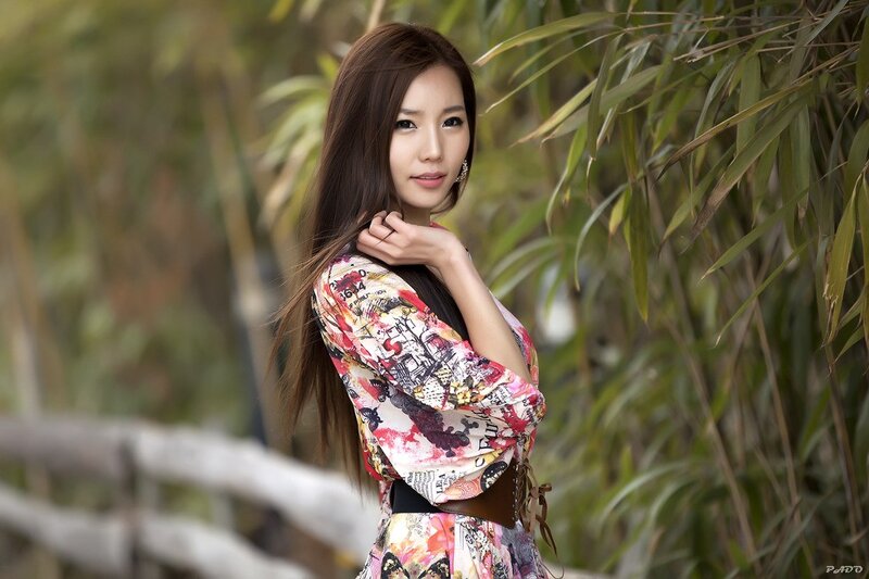woman in floral dress by bamboo