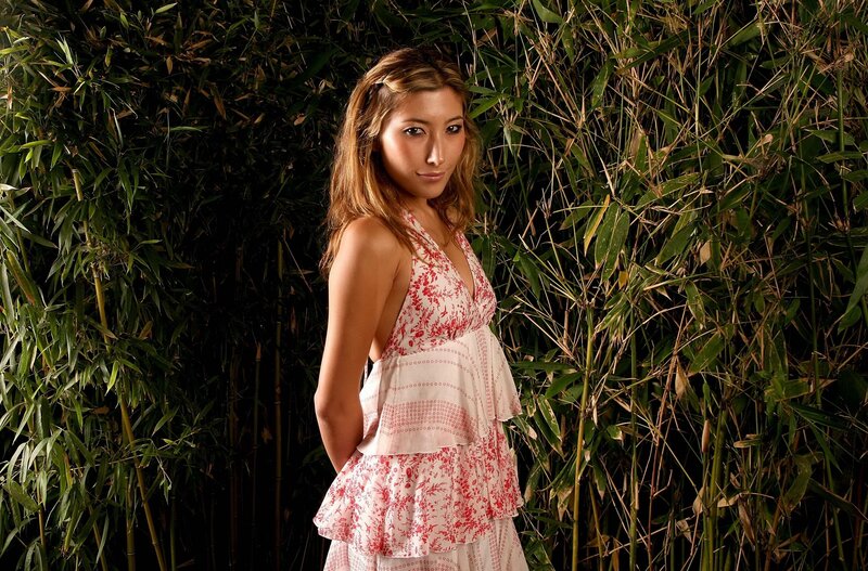 woman in floral dress by bamboo