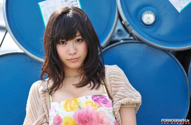 Woman in floral dress by blue barrels