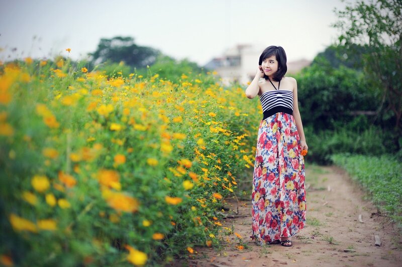 Woman in floral dress by flower field