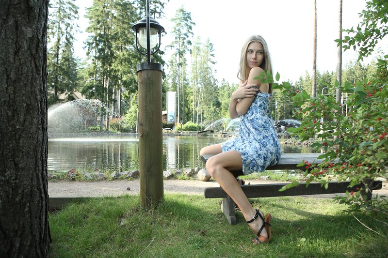 Woman in floral dress by pond