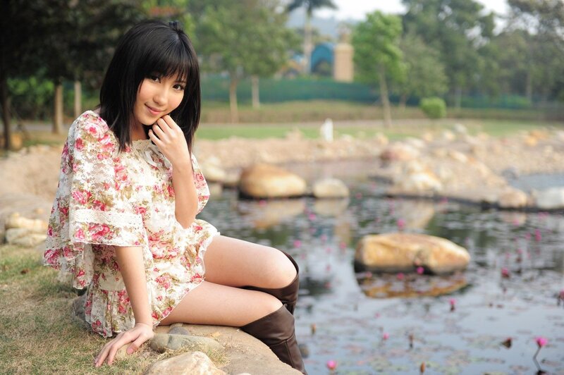 Woman in floral dress by pond