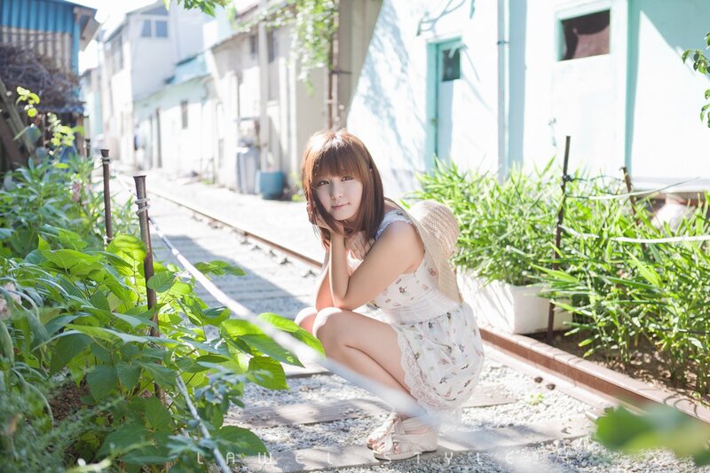 Woman in floral dress by train tracks