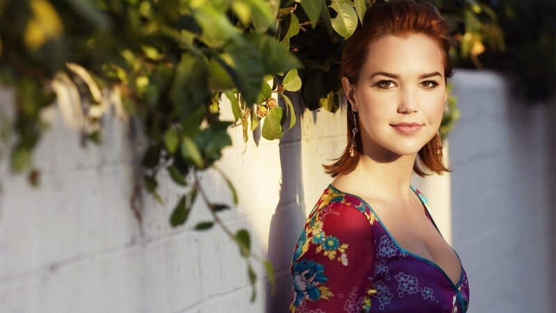 woman in floral dress by wall