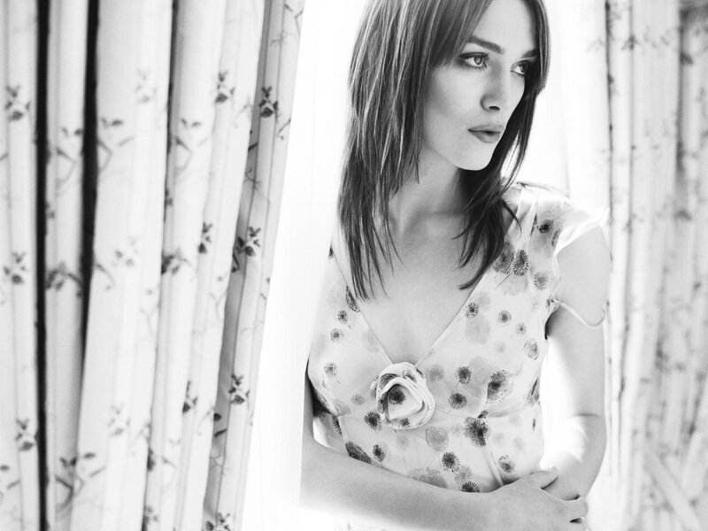 woman in floral dress by window