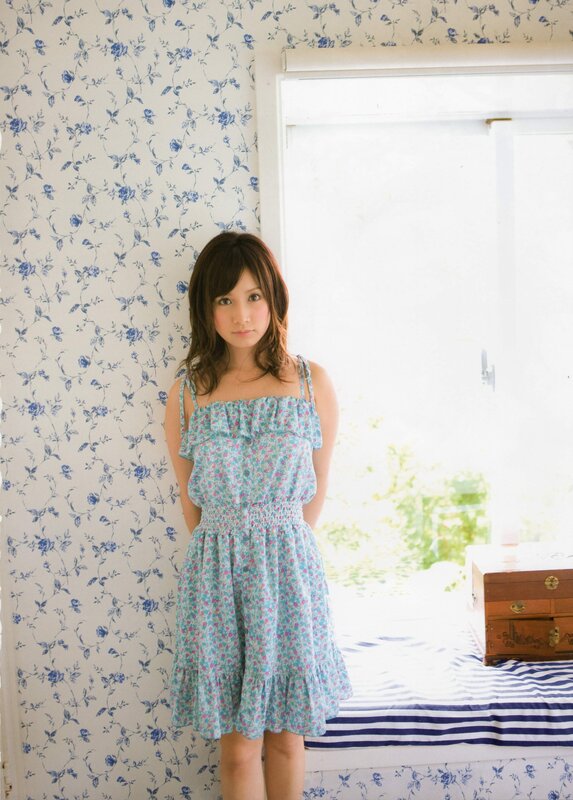 woman in floral dress by window