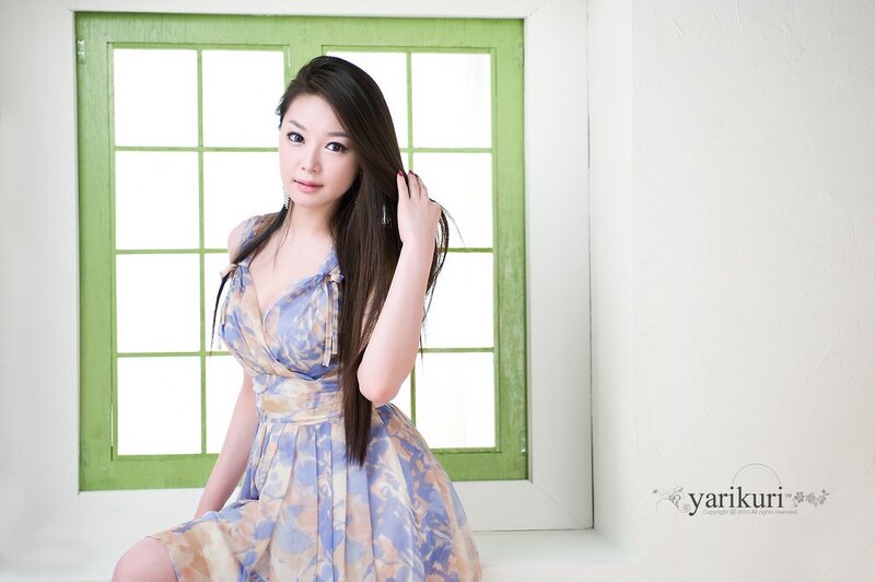 woman in floral dress by window