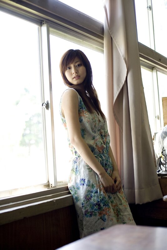 woman in floral dress by window