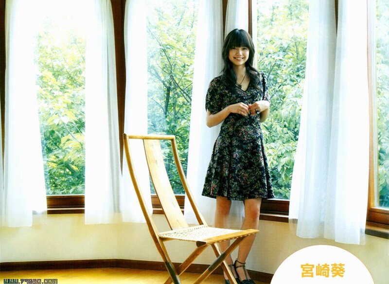 Woman in floral dress by window