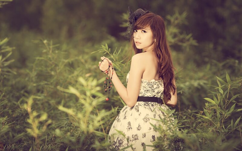 woman in floral dress holding beads