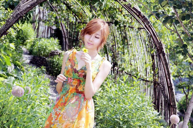 Woman in floral dress holding flower