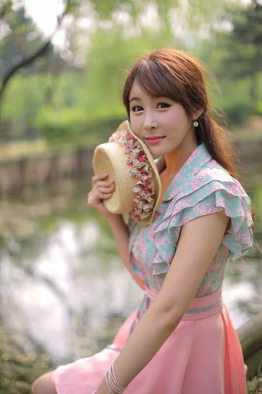 woman in floral dress holding hat