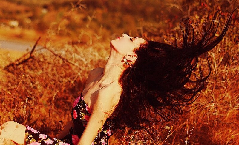 woman in floral dress lying in field