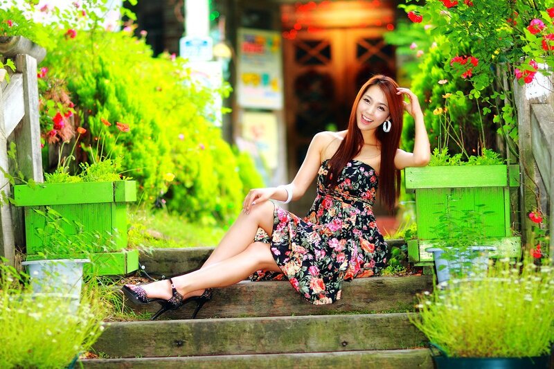 Woman in floral dress on garden steps