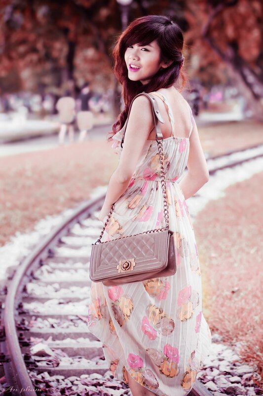 Woman in floral dress on train tracks