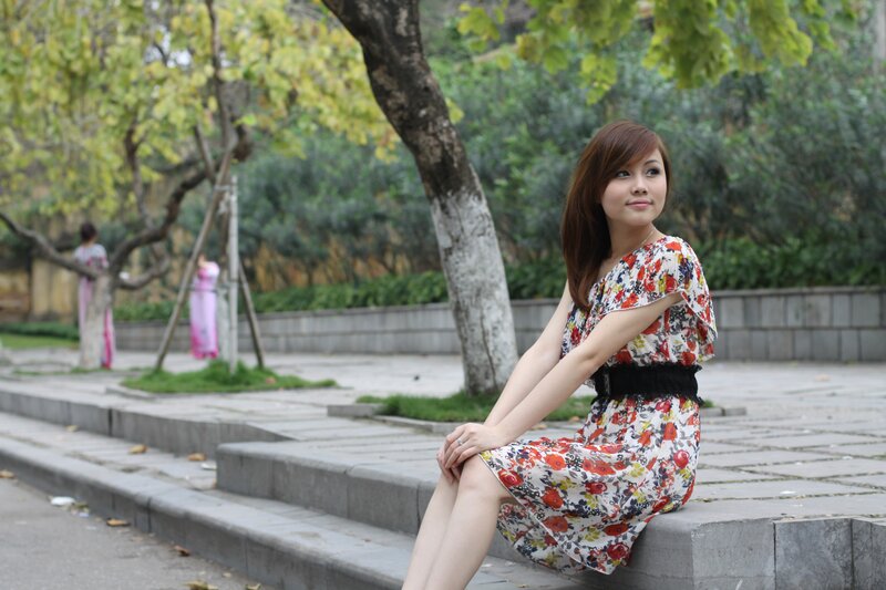 Woman in floral dress sitting on steps